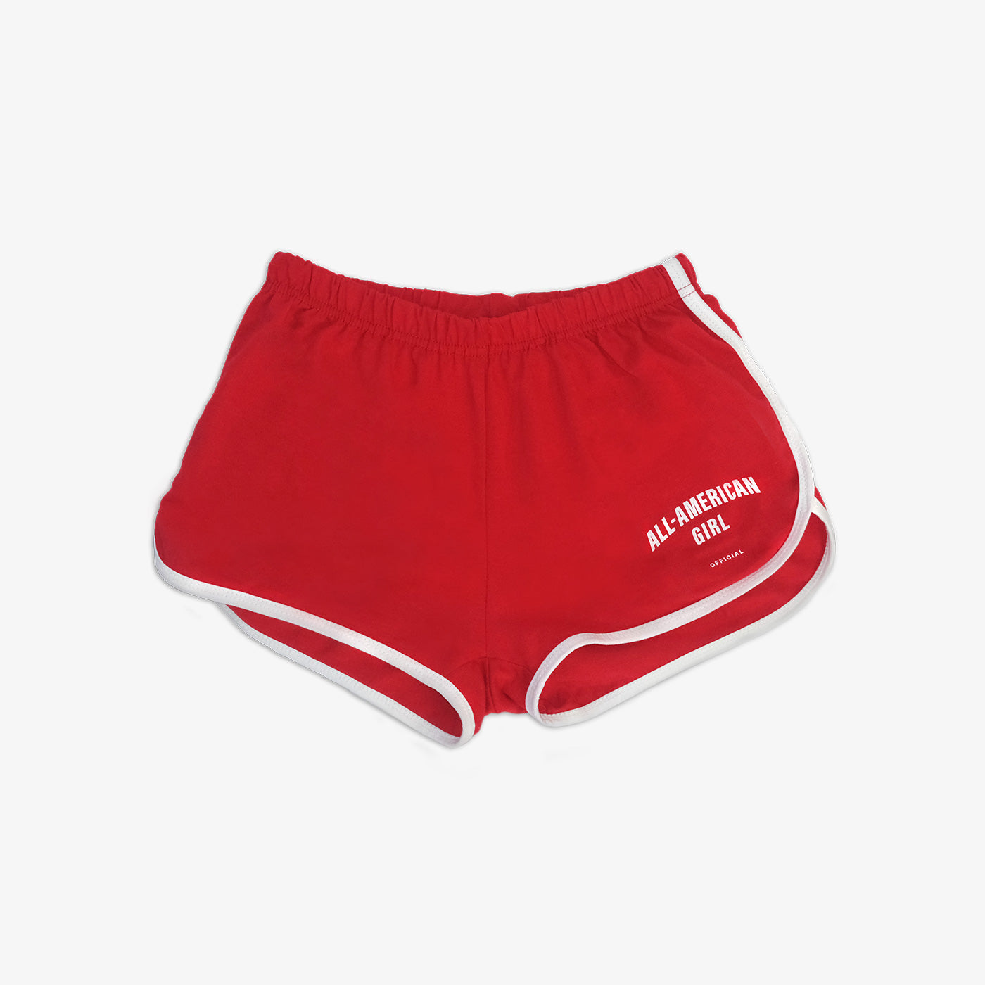 A girl wearing red All-American Girl track shorts. The shorts say All-American Girl Official on them. This is a comfortable pair of shorts perfect for working out, lounging, or casual style. These shorts come in small, medium, and large.